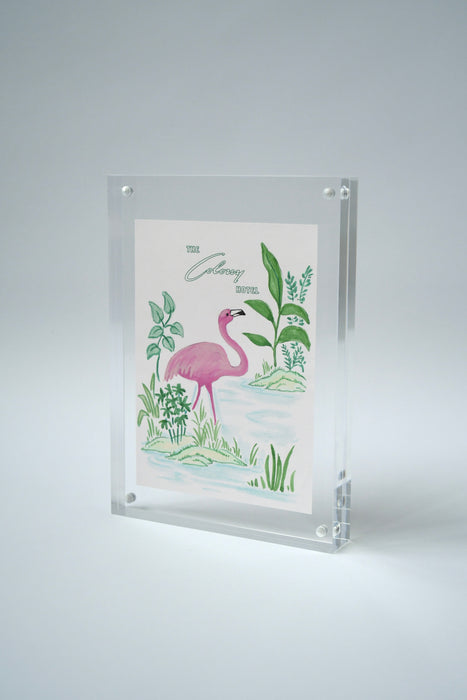 Colony Hotel flamingo painting standing upright in an acrylic frame