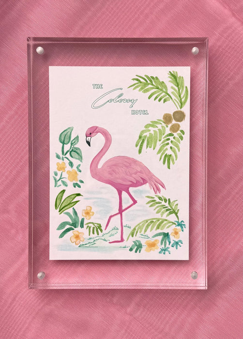 Framed Colony Hotel flamingo painting photographed against a pink background