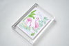 Angled view of framed Colony Hotel flamingo artwork in a clear acrylic block