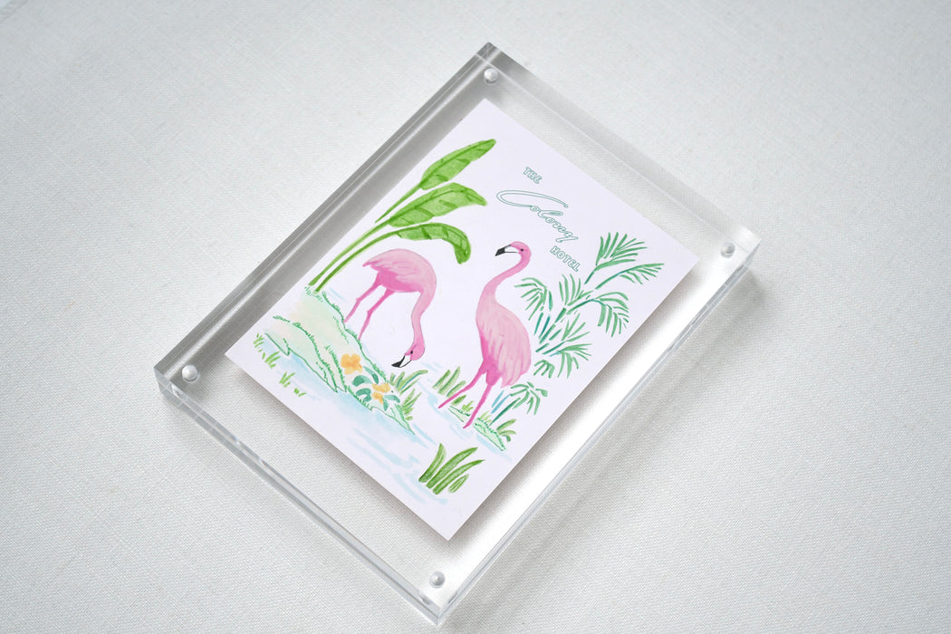 Angled view of framed Colony Hotel flamingo artwork in a clear acrylic block