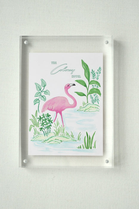 Colony Hotel flamingo painting displayed in a clear acrylic block frame