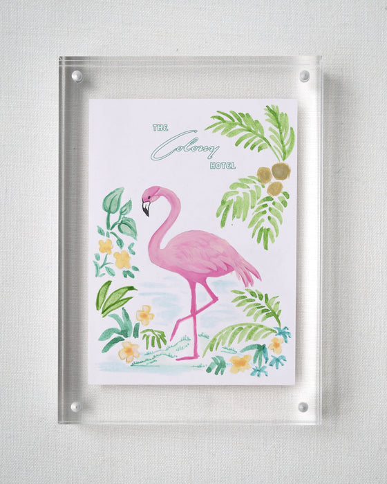 Colony Hotel flamingo painting displayed in a clear acrylic block frame